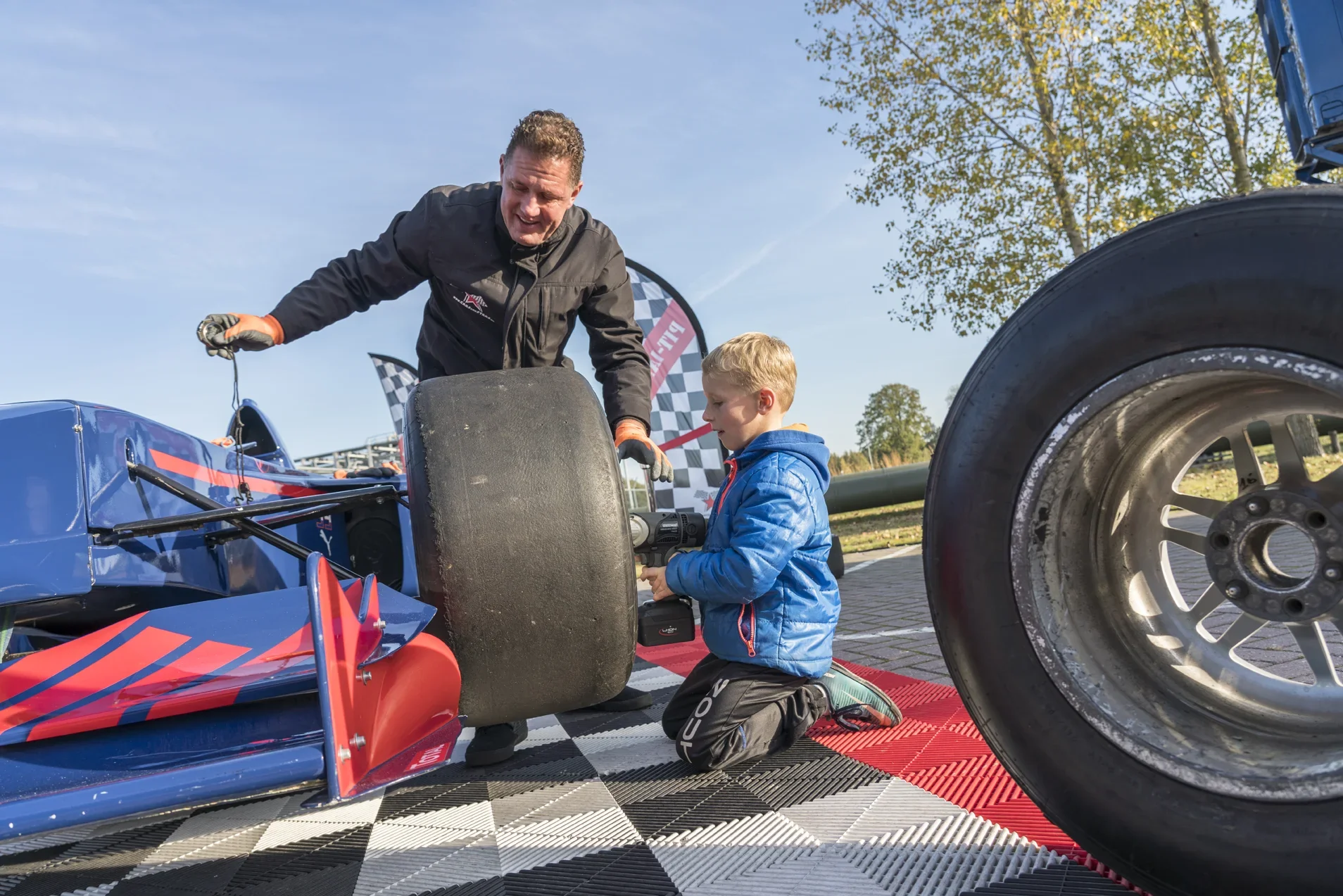 Vader en jong kind bekijken een formuleraceauto