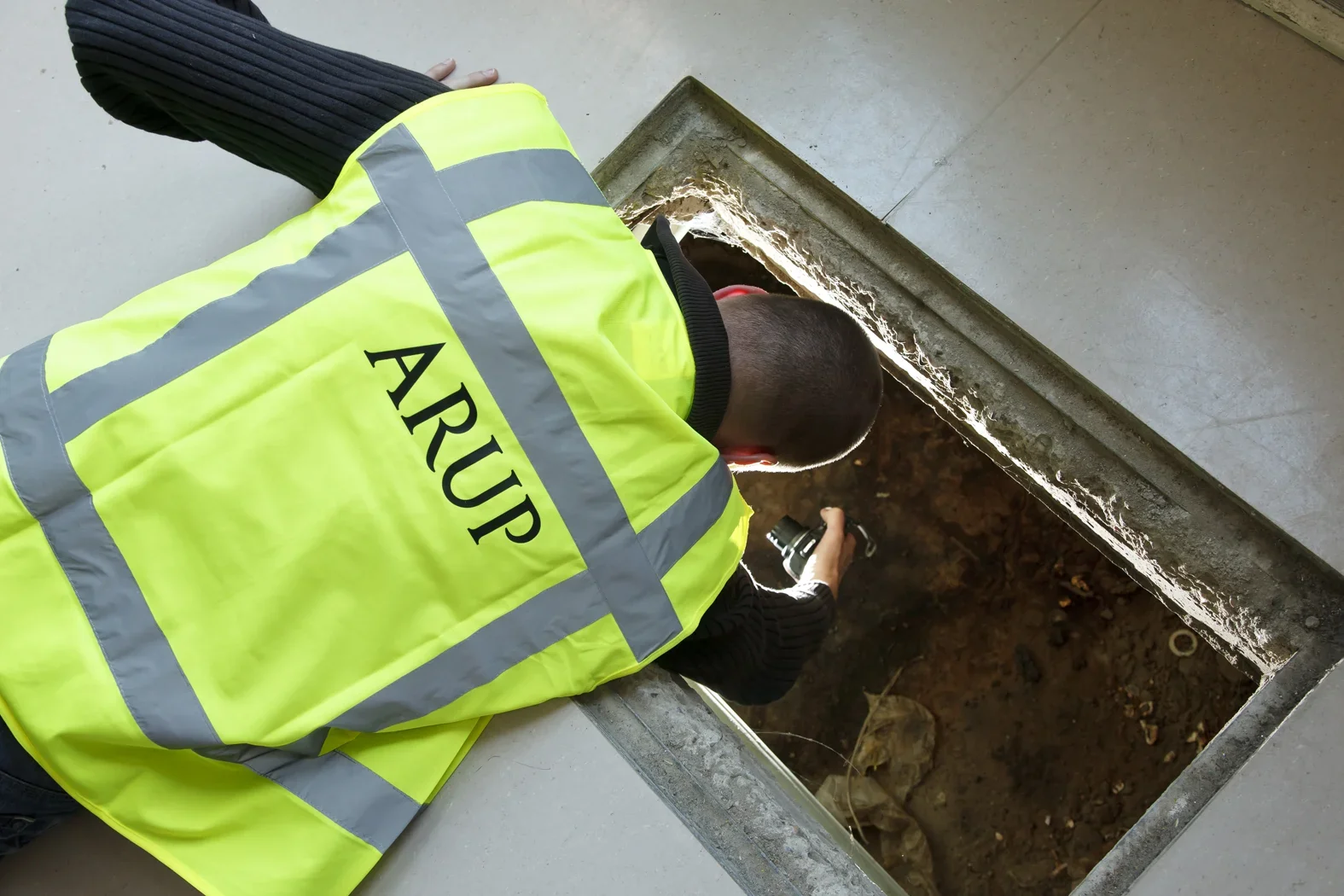 ARUP ingenieur in hesje inspecteert een mangat