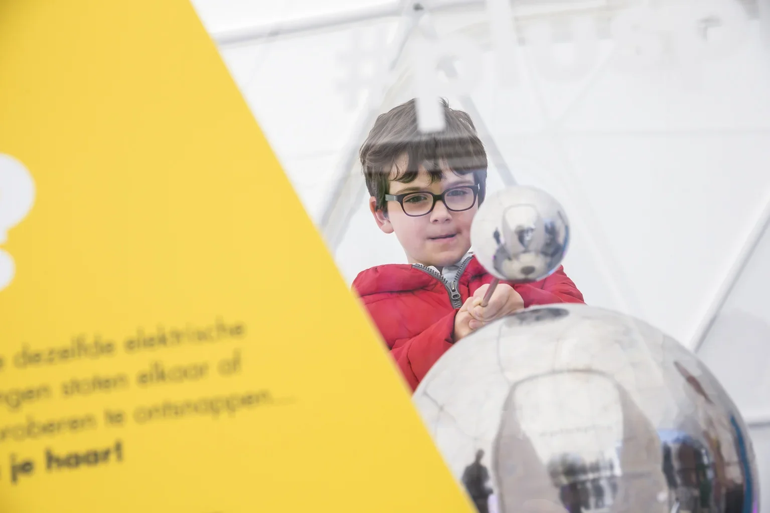 Kind met een kleine robot op een wetenschapstentoonstelling