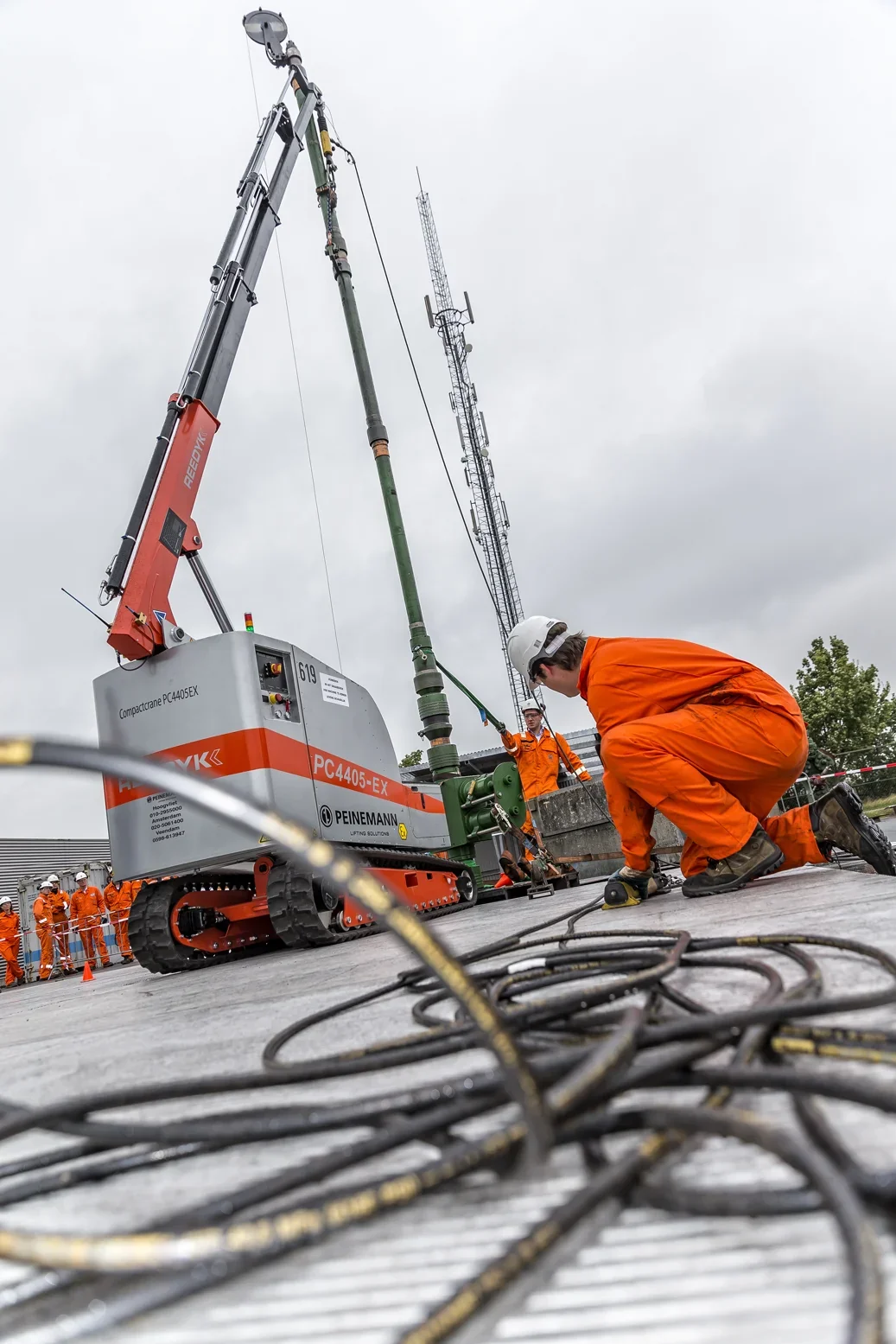 Medewerker in oranje pak bedient booruitrusting