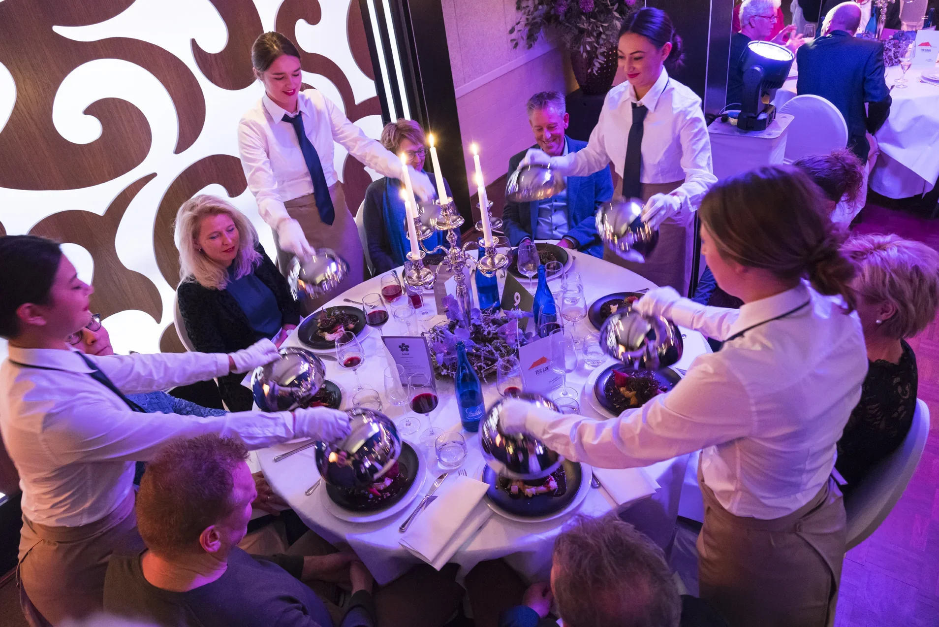 Gasten worden bediend aan een feestelijke eettafel