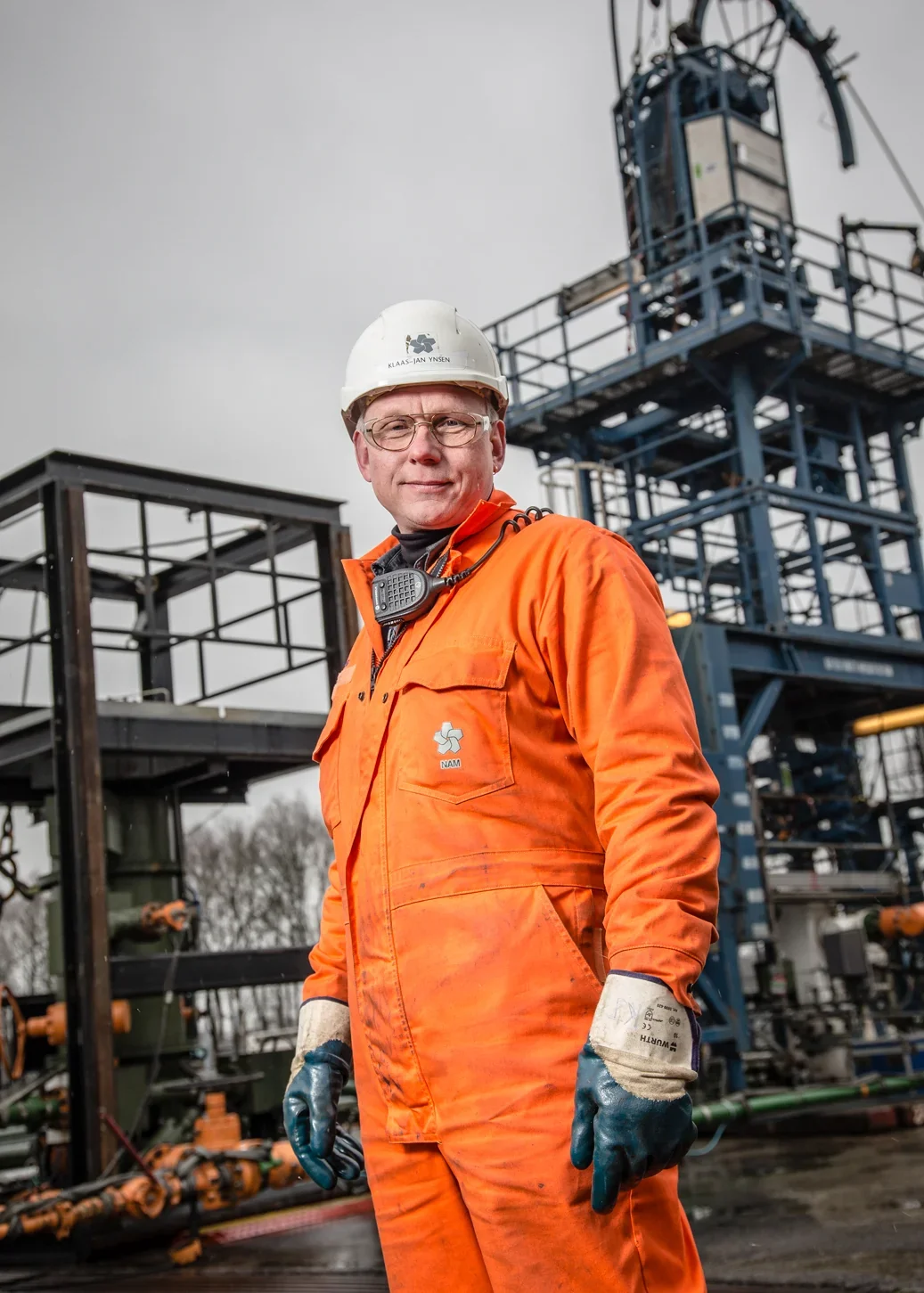 Medewerker in oranje pak bij een olie- en gasinstallatie