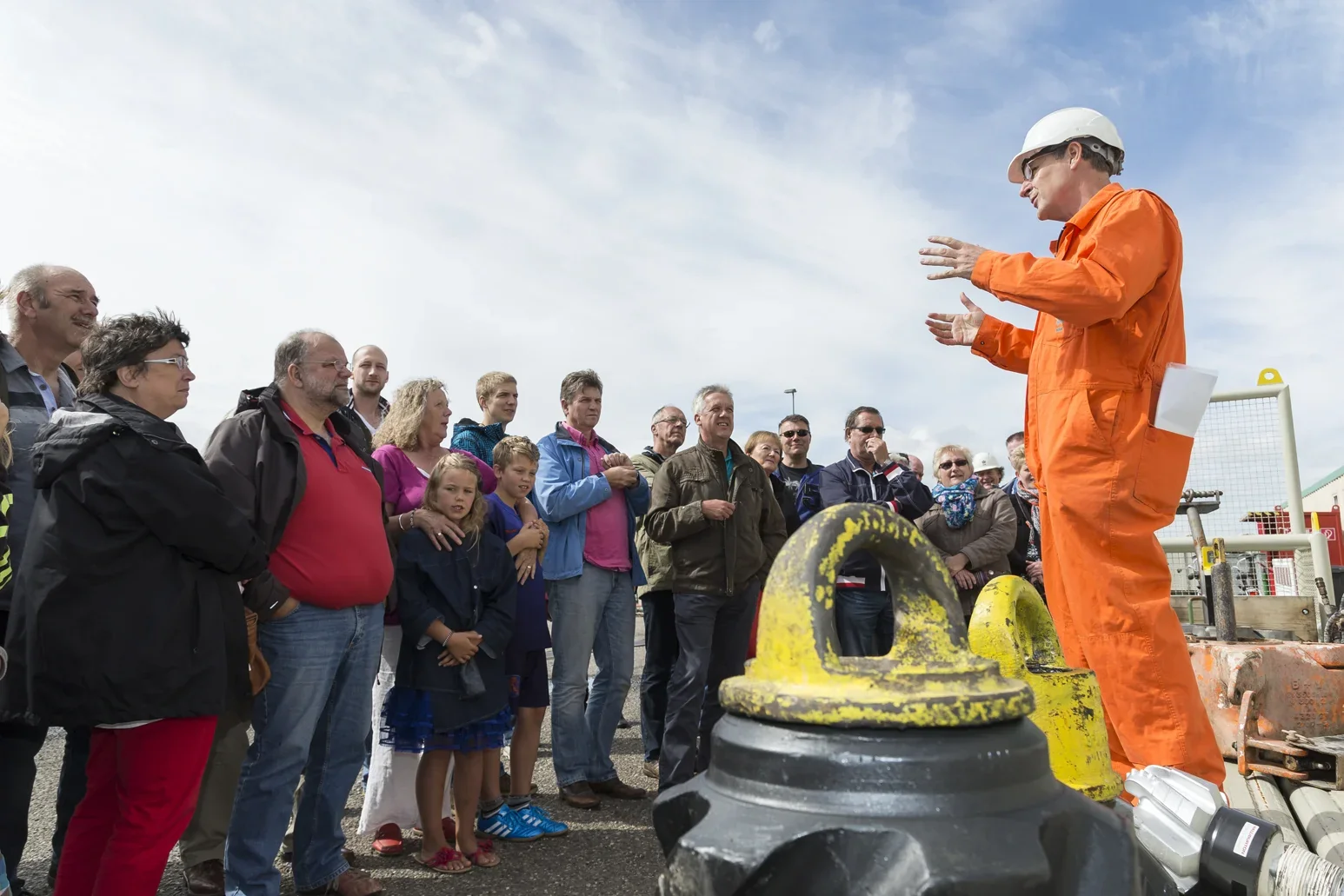 Groep kijkt naar een veiligheidsdemonstratie op een industriële open dag