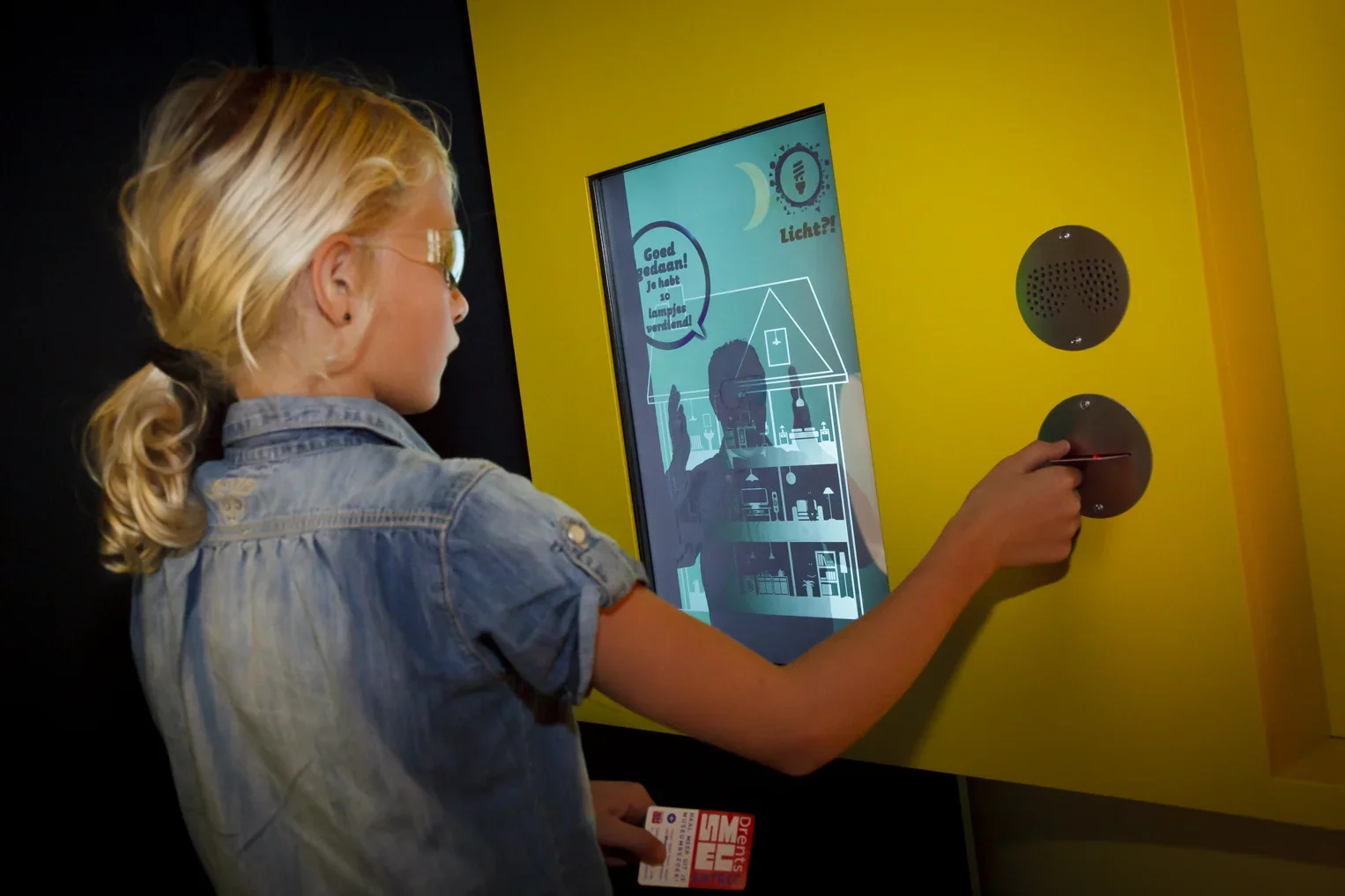 Vrouw interacteert met een geel touchscreenkiosk
